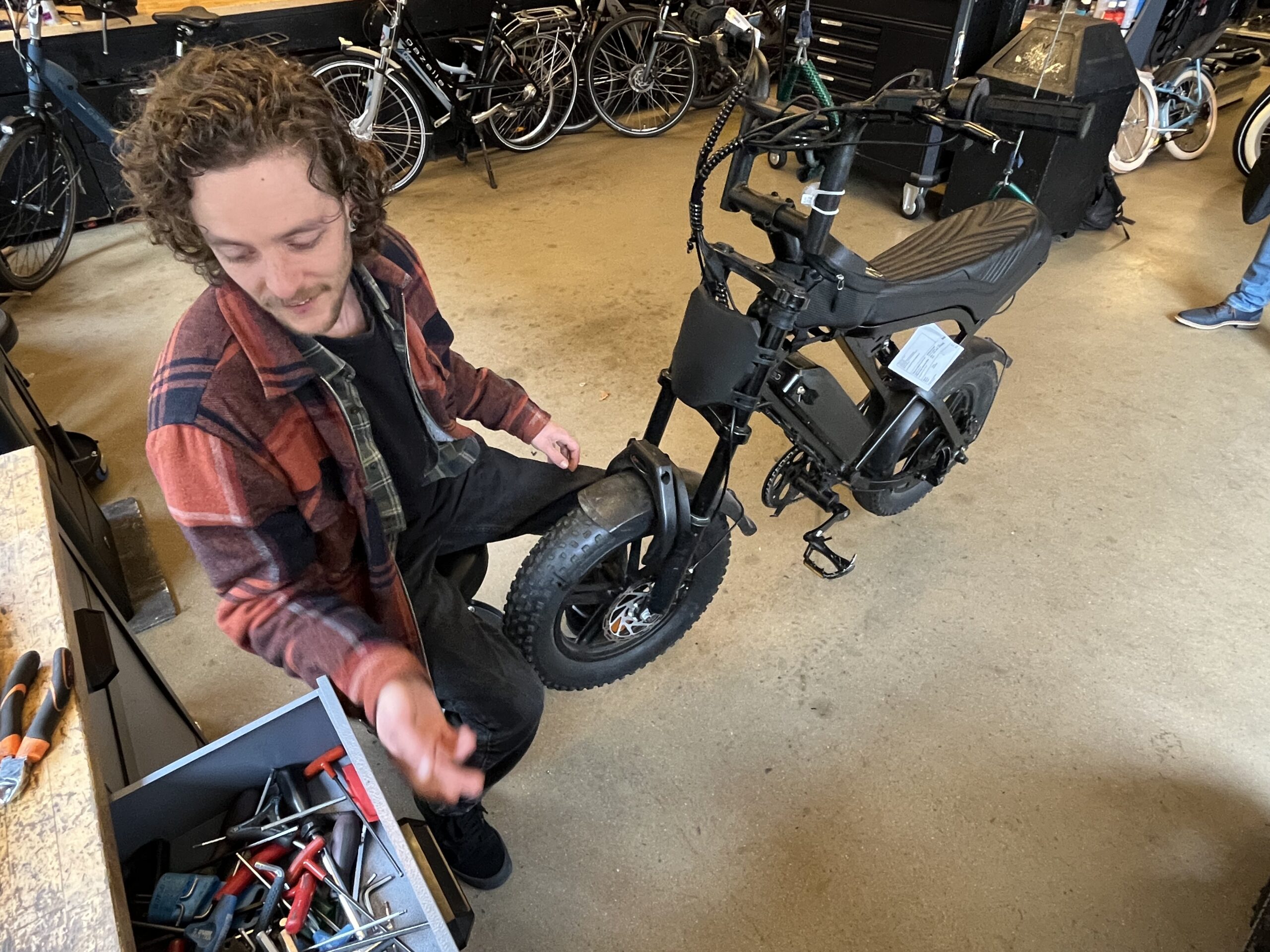 Lars IJzerman repareert een fatbike in de werkplaats